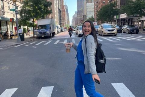 YLC member Hilary walking across a crosswalk and smiling