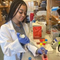 Woman holding pipette and test tube in the lab