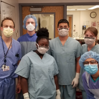 Team of scientists wearing masks gathered for a photo in a lab