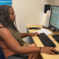 Woman scrolling through computer screen at a desk